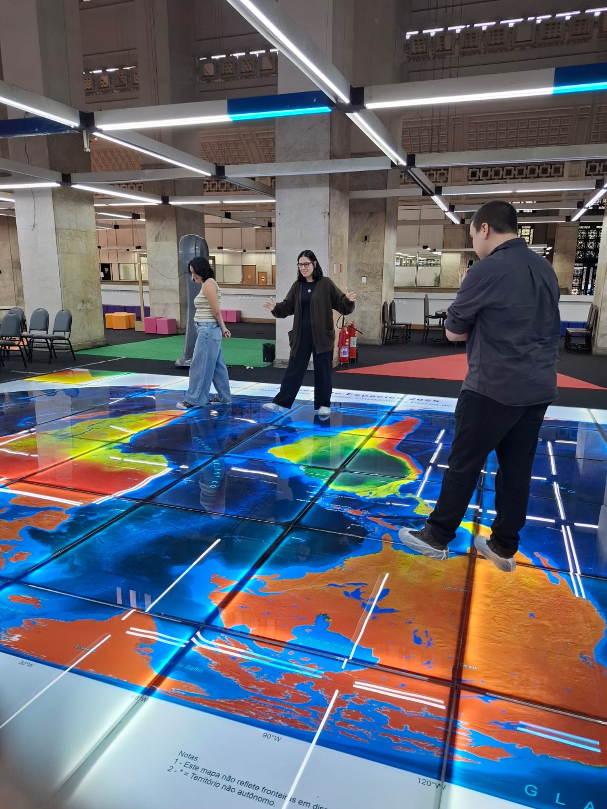 Jogadores da Expedição Mapa Múndi procuram um país no mapa.